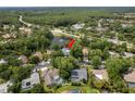A captivating aerial view showing the home nestled among lush trees with a serene pond as its backdrop at 3138 Edgemoor Dr, Palm Harbor, FL 34685