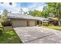 Charming single-story home features a gray stone front, beautiful landscaping, and an attached two car garage at 3138 Edgemoor Dr, Palm Harbor, FL 34685