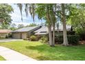 Beautiful one-story home featuring lush landscaping, an attached two car garage and mature trees at 3138 Edgemoor Dr, Palm Harbor, FL 34685