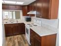 Updated kitchen featuring white appliances, wooden cabinets, and modern countertops at 3311 Teeside Dr, New Port Richey, FL 34655