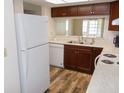 Efficient kitchen with wooden cabinets, white appliances, and durable countertops at 3311 Teeside Dr, New Port Richey, FL 34655