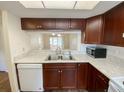 Well-lit kitchen featuring white countertops and wooden cabinetry with a view to the dining area at 3311 Teeside Dr, New Port Richey, FL 34655