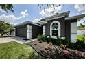 Charming gray home with a well-manicured lawn, attractive landscaping and trimmed bushes at 382 Tavernier Cir, Oldsmar, FL 34677