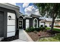 Close-up of the front door, landscaping and the column-style accents on the porch at 382 Tavernier Cir, Oldsmar, FL 34677