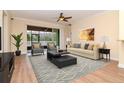 Well-lit living room with modern furnishings, hardwood floors, and sliding door to the patio at 3914 Round Table Ct, Land O Lakes, FL 34638