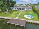 Waterfront backyard featuring a dock, fire pit, hammock, stepping stones, and patio seating area, perfect for outdoor relaxation at 3922 Fontainebleau Dr, Tampa, FL 33634