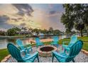 Outdoor fire pit surrounded by six chairs overlooking the waterfront for cozy evenings at 3922 Fontainebleau Dr, Tampa, FL 33634
