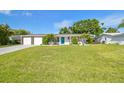 Single-story home boasts lush landscaping, a vibrant blue front door, and a convenient two-car garage at 3922 Fontainebleau Dr, Tampa, FL 33634