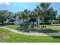 Charming light blue two-story home with well-manicured lawn and palm tree landscaping at 4063 Ligustrum Dr, Palm Harbor, FL 34685