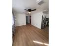 Living room with wood floors, ceiling fan, view of kitchen, white trim, and neutral wall paint at 4112 Alafia Blvd, Brandon, FL 33511
