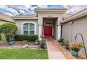 Welcoming front entrance with a brick walkway leading to a vibrant red double-door entry at 5132 Pinnacle Dr, Oldsmar, FL 34677