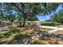 Charming single-story home with stone accents, a well-manicured lawn, and mature shade trees at 518 62Nd Ne Ave, St Petersburg, FL 33702