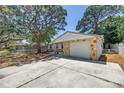 Charming single-story home featuring stone accents, garage and concrete driveway at 518 62Nd Ne Ave, St Petersburg, FL 33702