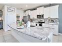 Bright kitchen with granite countertops, stainless steel appliances, and a large island at 5464 Flint Hills Dr, Wimauma, FL 33598