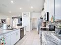 Bright kitchen with granite countertops, stainless steel appliances, and tiled floors at 5464 Flint Hills Dr, Wimauma, FL 33598