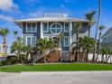 Striking modern home showcasing a unique circular window, sleek lines, and lush landscaping at 5820 Balao S Way, St Pete Beach, FL 33706