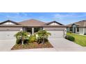 Beautiful home featuring a two-car garage, well-maintained landscaping and a cozy front porch at 6206 Mooring Line Cir, Apollo Beach, FL 33572