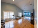 Open-concept living room with hardwood floors, sliding glass doors to the lanai, and a modern ceiling fan at 6438 Brentwood Dr, Zephyrhills, FL 33542