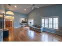 Spacious living room with vaulted ceilings, hardwood floors, and large windows providing ample light at 6438 Brentwood Dr, Zephyrhills, FL 33542