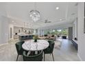 Open-concept living space with a decorative chandelier over a marble table with seating, flowing to kitchen at 6440 Maiden Sea Dr, Apollo Beach, FL 33572