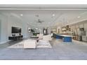 Spacious living area showcasing an open layout with modern finishes, including gray tile and stainless steel appliances at 6440 Maiden Sea Dr, Apollo Beach, FL 33572