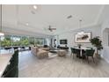 Bright, open-concept living room with modern finishes, tile floors, and a view of the outdoor pool at 6440 Maiden Sea Dr, Apollo Beach, FL 33572