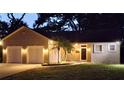Charming single-story home featuring a two-car garage, landscaped yard, and a classic front entrance at dusk at 6994 Fort King Rd, Zephyrhills, FL 33541