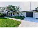 Beautiful single-story home with a modern garage, complemented by a lush green lawn at 8444 15Th N Way, St Petersburg, FL 33702