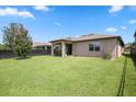 Exterior view of house with large lawn and black chain link fence at 9309 Tradewater Oaks Ct, Riverview, FL 33578