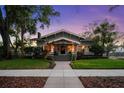 Charming bungalow at twilight with manicured lawn and beautiful landscaping, creating great curb appeal at 1001 S Oregon Ave, Tampa, FL 33606