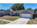 View of home with an attached garage, light blue front door, and curb appeal at 1005 Cameo Crest Ln, Valrico, FL 33596