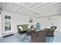 Comfortable screened porch with wicker seating and access to the laundry room at 10442 Cirimoya Ln, Seminole, FL 33772