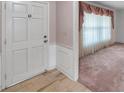 View of the home's entryway, featuring a classic white door and trim with neutral tile flooring at 111 W Anglewood Dr, Brandon, FL 33511
