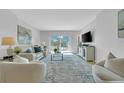 Bright and airy living room with balcony access, light-colored furniture, and a modern rug at 1120 N Shore Ne Dr # 201, St Petersburg, FL 33701