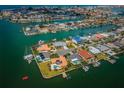 Aerial view of waterfront community featuring canal access, docks, lush landscaping and houses with swimming pools at 11625 5Th E St, Treasure Island, FL 33706