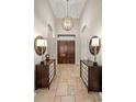 Grand foyer entrance with decorative lighting, double doors, and travertine flooring at 13208 Malachite Dr, Bradenton, FL 34211