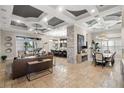 Open-concept living and dining area featuring stone accents, tile floors, and tray ceilings at 13208 Malachite Dr, Bradenton, FL 34211