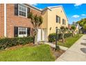 Charming brick and siding townhouse exterior with well-maintained landscaping and inviting curb appeal at 13696 Orange Sunset Dr, Tampa, FL 33618