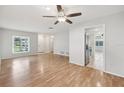 Bright living room with hardwood floors, ceiling fan, and open access to the kitchen at 1605 W Dorchester Dr, Palm Harbor, FL 34684
