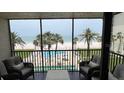 Screened balcony view of the community pool, beach, and ocean, with comfortable outdoor seating at 18304 Gulf Blvd # 309, Redington Shores, FL 33708