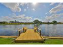 Wooden dock on the water with built in benches and tranquil water views at 2003 Wedge Ct, Sun City Center, FL 33573