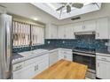 Updated kitchen featuring modern appliances, stylish backsplash and bright skylight at 2537 Oakleaf Ln # 32A, Clearwater, FL 33763
