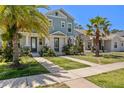 Inviting townhome with a well-manicured lawn, walkway, and lush palm trees adding to its curb appeal at 2708 W North B St # 3, Tampa, FL 33609