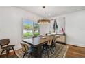 Formal dining area featuring a large wood table, modern chandelier, and ample natural light at 3008 S Church Ave, Tampa, FL 33629