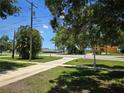 Scenic view of a quiet residential street with lush greenery and glimpses of a waterfront at 315 Shore E Dr, Oldsmar, FL 34677
