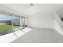 Bright and spacious living room with tile flooring and large windows offering great natural light and backyard views at 3488 Great Banyan Way, Wesley Chapel, FL 33543