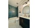 Stylish bathroom with blue tiled shower, mosaic tile flooring, and a modern vanity with gold fixtures at 4202 N Suwanee Ave, Tampa, FL 33603