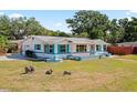 Beautiful single-story home featuring turquoise accents, a well-maintained lawn, and mature trees at 4421 28Th N Ave, St Petersburg, FL 33713