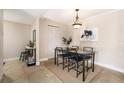 Dining room with neutral paint, tile floor, modern table, contemporary light fixture and artwork at 455 Alt 19 S # 65, Palm Harbor, FL 34683