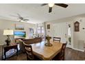 Inviting living room featuring wood floors, ceiling fan, dining table, and plenty of natural light at 5137 Springwood Dr, Tampa, FL 33624
